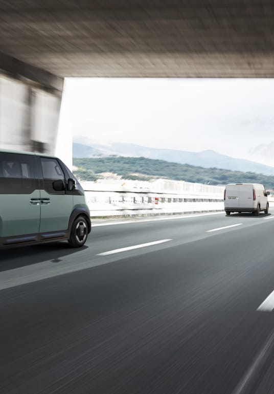 Kia PV5 WAV fährt auf der Autobahn – der Autobahnassistent hält Geschwindigkeit, Abstand und Spurposition.